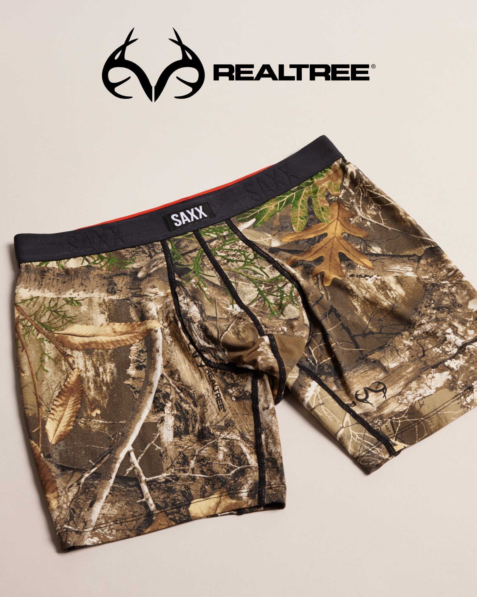Camouflage SAXX underwear on a beige background, featuring the Realtree logo.