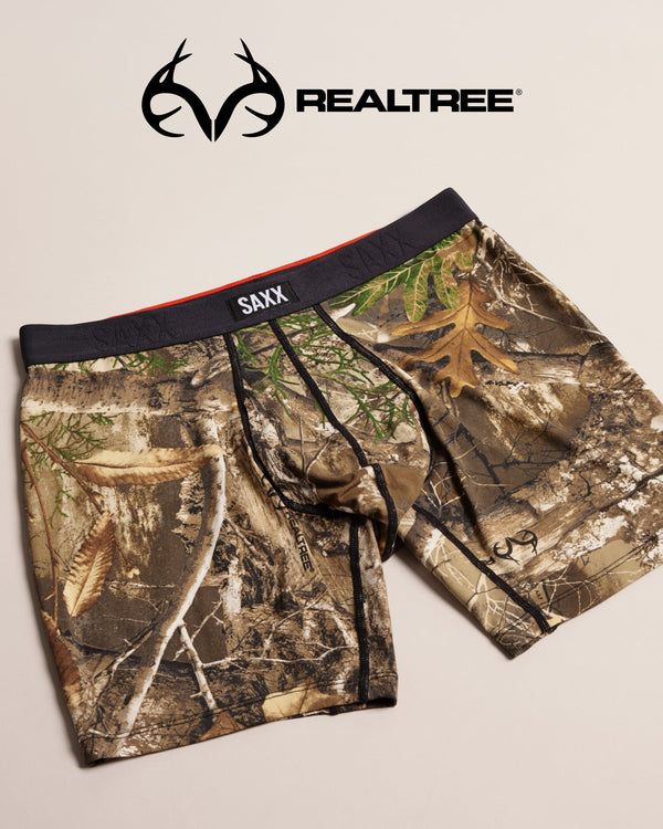 Camouflage SAXX underwear on a beige background, featuring the Realtree logo.