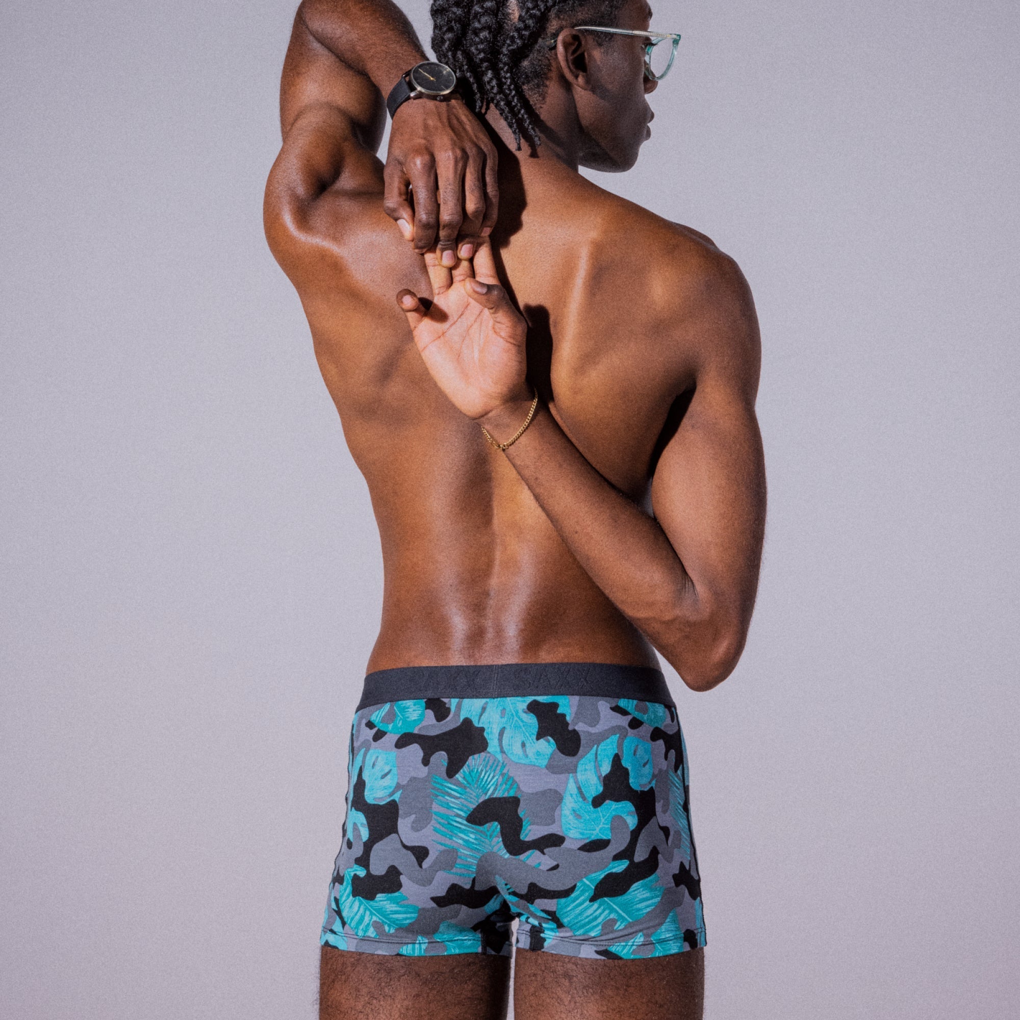 Model posing in Vibe Super Soft Trunk in Island Camo- Black